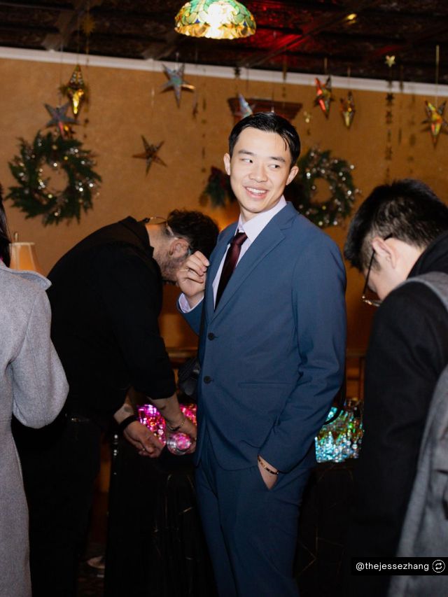 Decagon Co-founder Jesse Zhang Net Worth, AI Startup Journey, Vision & Growth 2 Jesse Zhang, Decagon co-founder, smiles in a blue suit at an event decorated with wreaths and stars for a net worth feature.