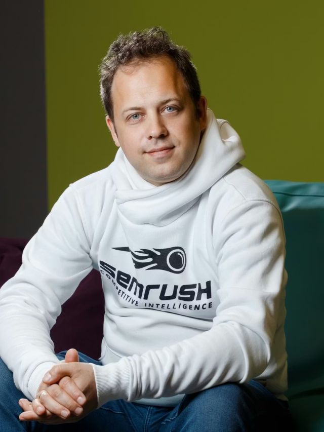 Oleg Shchegolev Net Worth, Semrush Founder Success Story, Vision and Expansion 2
Oleg Shchegolev, the founder of Semrush, sits in a white hoodie with his hands clasped, smiling at the camera.