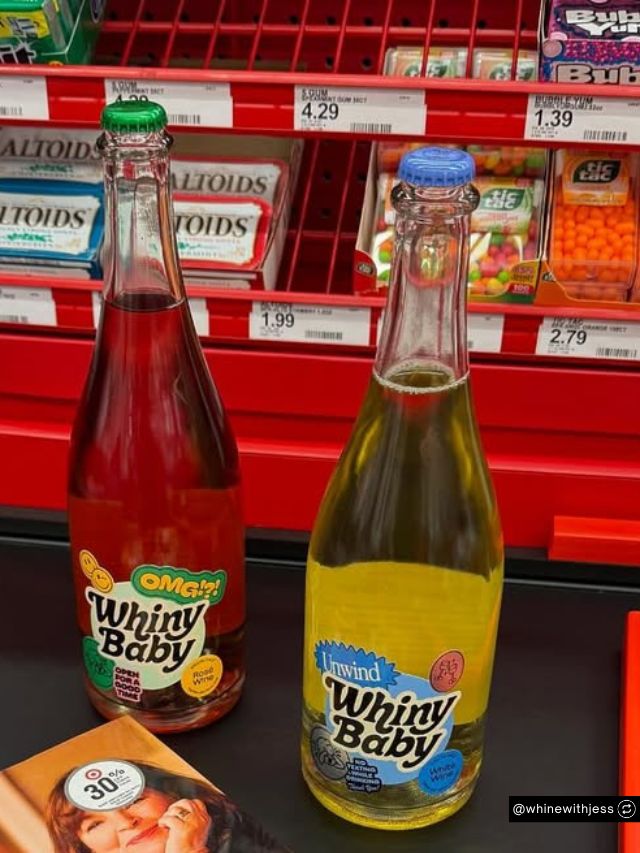 Founder Jess Druey’s Whiny Baby Wine bottles sit on a checkout counter near candy displays at a store.