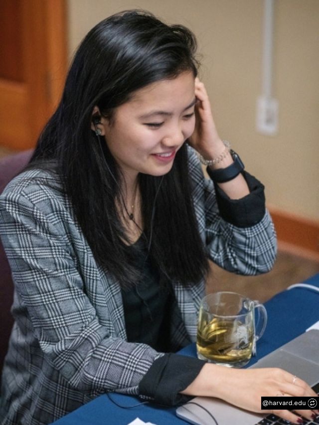 Alta Founder Jenny Wang Net Worth, Journey, Vision & Startup Growth 2
Jenny Wang, the founder of Alta, smiles while working on her laptop, wearing a grey plaid blazer and focused on her task.